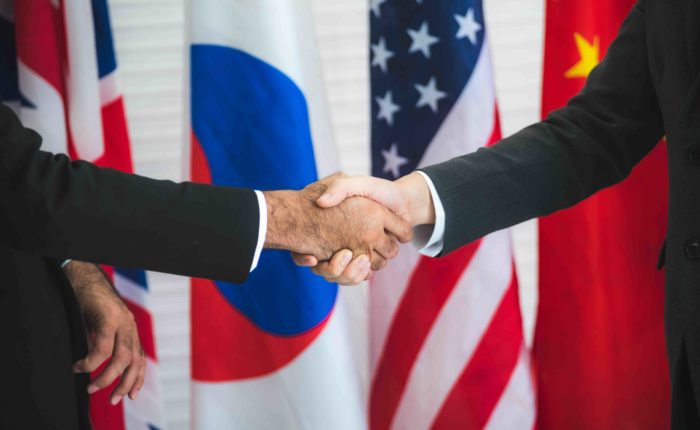 businessmen closing an international trade treaty with a handshake