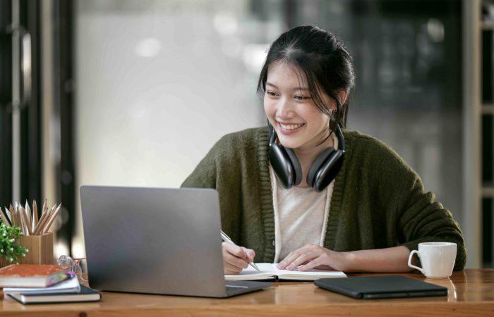 Portrait confident young female college student studying online via laptop computer
