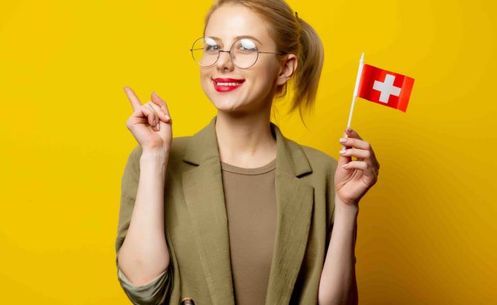 A professional is celebrating, with a Swiss flag, that she got into an MBA.