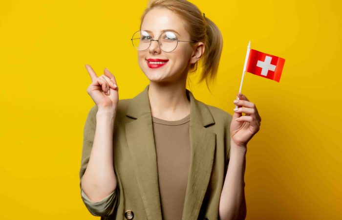 A professional is celebrating, with a Swiss flag, that she got into an MBA.